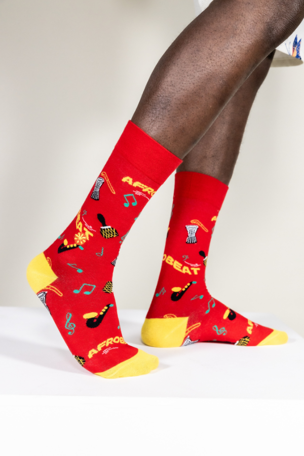 Red socks. Afrobeat socks is a celebration of Afrobeat. The West African music genre was pioneered in the 1960s by Nigerian artist, Fela Kuti. It is a mixture of traditional Yoruba music such as fuji and other contemporary sounds of the time, like jazz and soul.

Instruments on socks: shekere, djembe drum, talking drum, saxophone