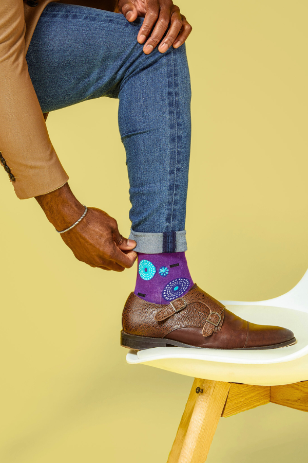 Purple socks. The Ghanaian name for the textile that inspired this design is Nsu Bra, an Akan word meaning "water well". The tiny dots are meant to resemble the ripples that are formed after water has been fetched.

In Nigeria, it is referred to as "disk" or "record" for obvious reasons. 

In Togo, it is known as Gbedze, which references the straw hats worn as protection from the sun by royalty.